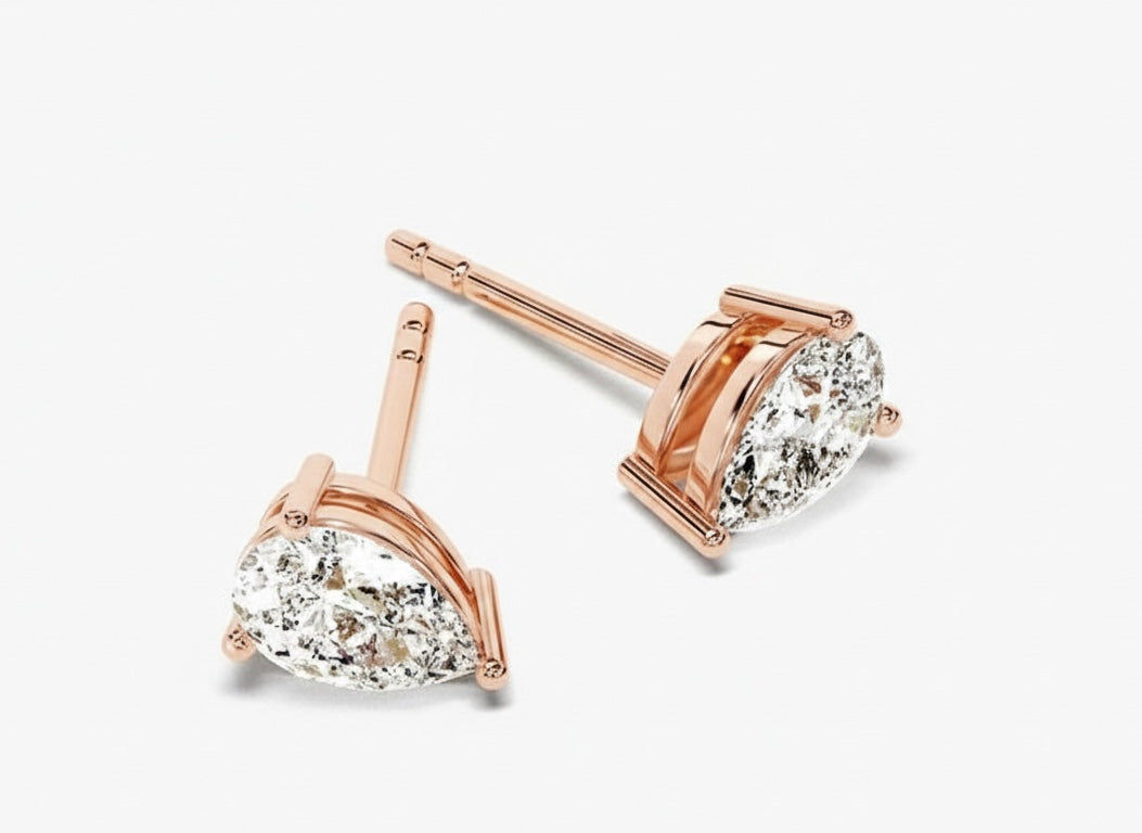 Rose gold earrings with pear-shaped diamondon a white background
