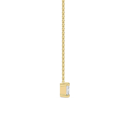 Side profile of custom emerald cut diamond necklace in gold highlighting setting and chain