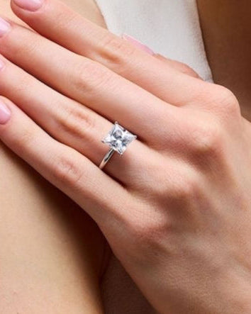 Hand wearing Princess solitaire ring in gold with lab-grown diamond showing scale and sparkle