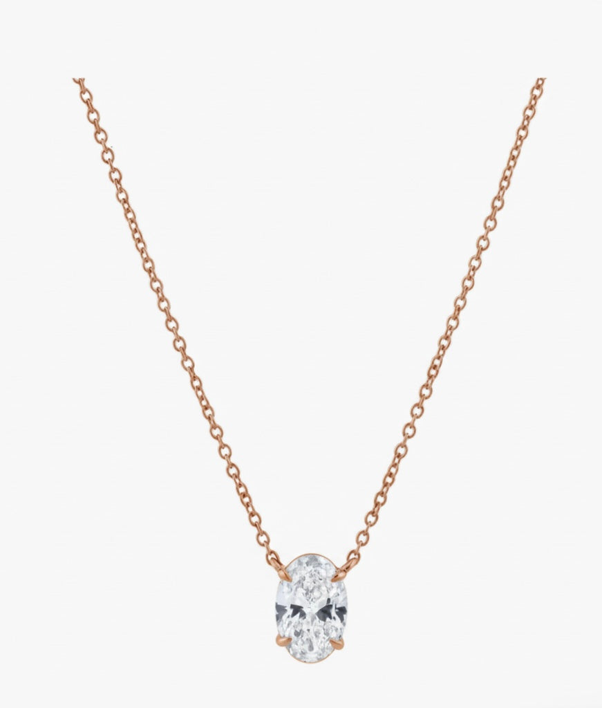 Rose gold necklace with a clear gemstone on a white background
