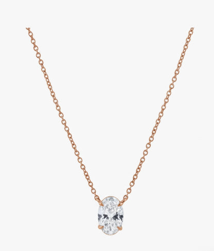 Rose gold necklace with a clear gemstone on a white background