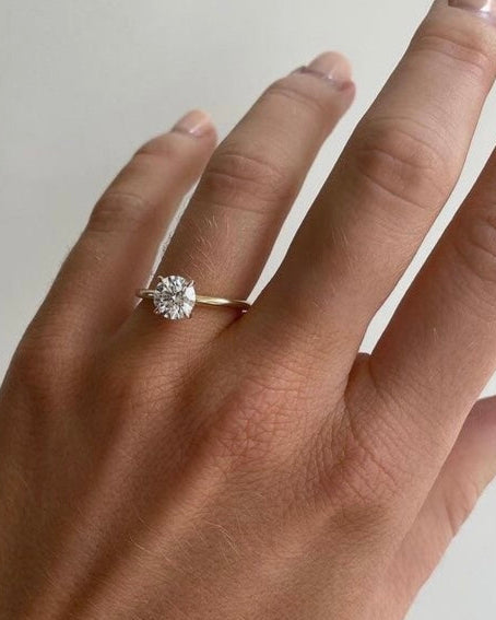 Hand wearing Round solitaire ring in gold with lab-grown diamond showing scale and sparkle