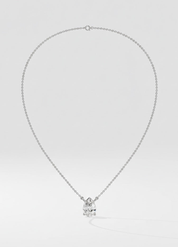 Silver necklace with a pear-shaped pendant on a light gray background