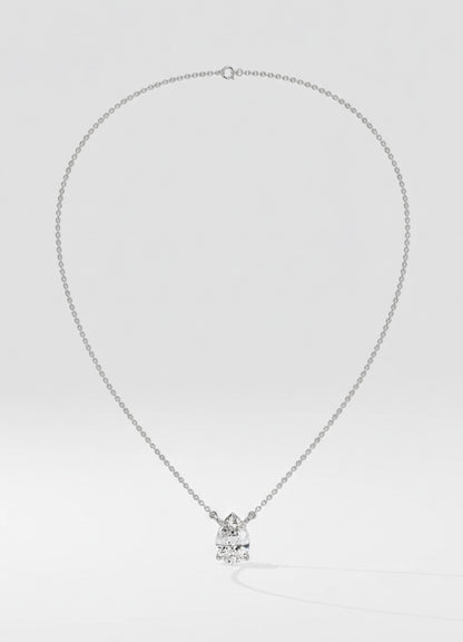 Silver necklace with a pear-shaped pendant on a light gray background