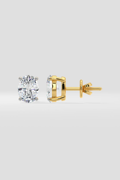 Gold stud earrings on a light gray background