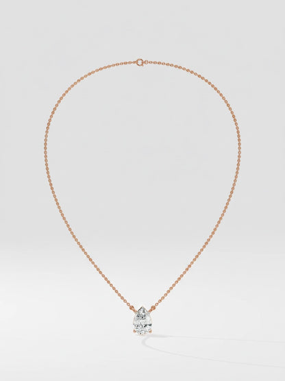 Rose gold necklace with a pear cut diamond pendant on a light gray background