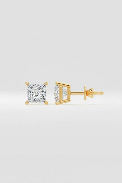 Gold diamond stud earrings on a light gray background
