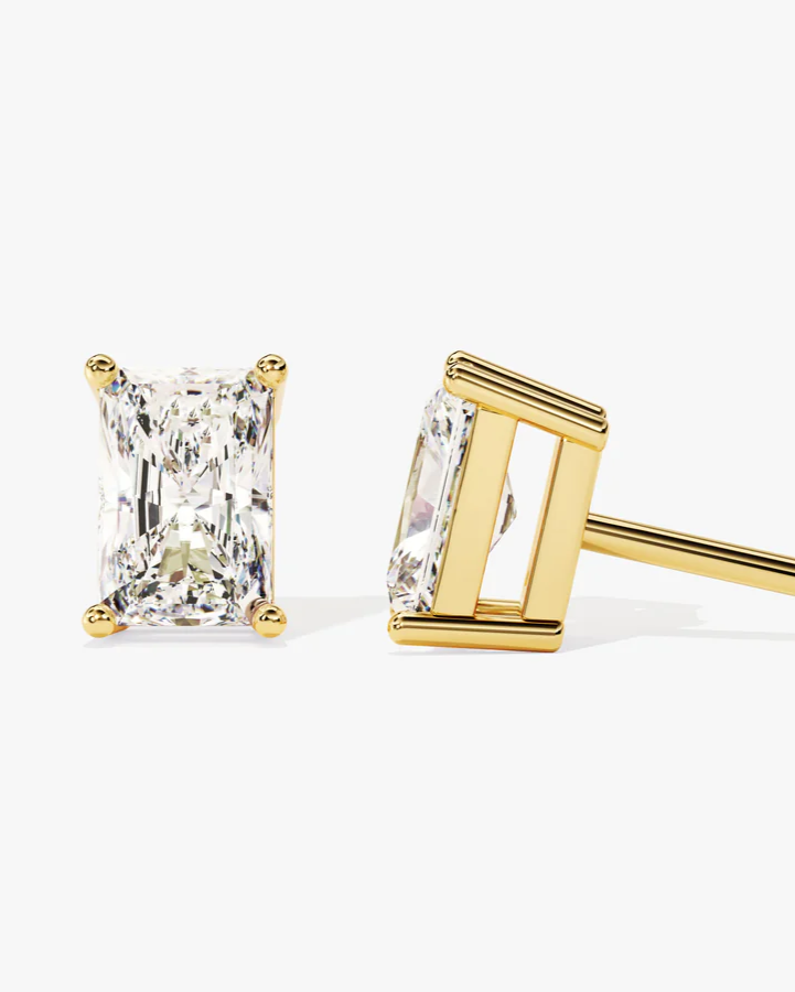 Gold stud earrings with rectangular cut diamond on a white background