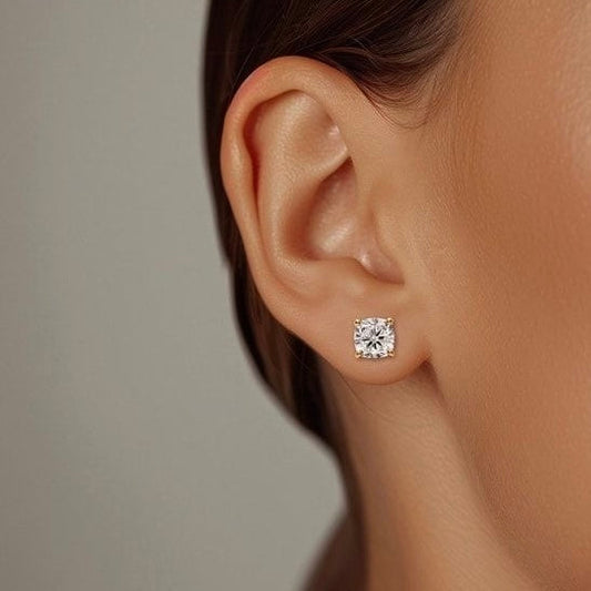Close-up of cushion solitaire earring worn on ear – elegant gold cushion diamond studs