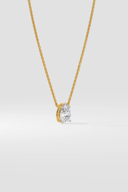 Side profile of custom pear cut diamond necklace in gold highlighting setting and chain