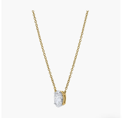 Side profile of custom oval solitaire diamond necklace in gold highlighting setting and chain